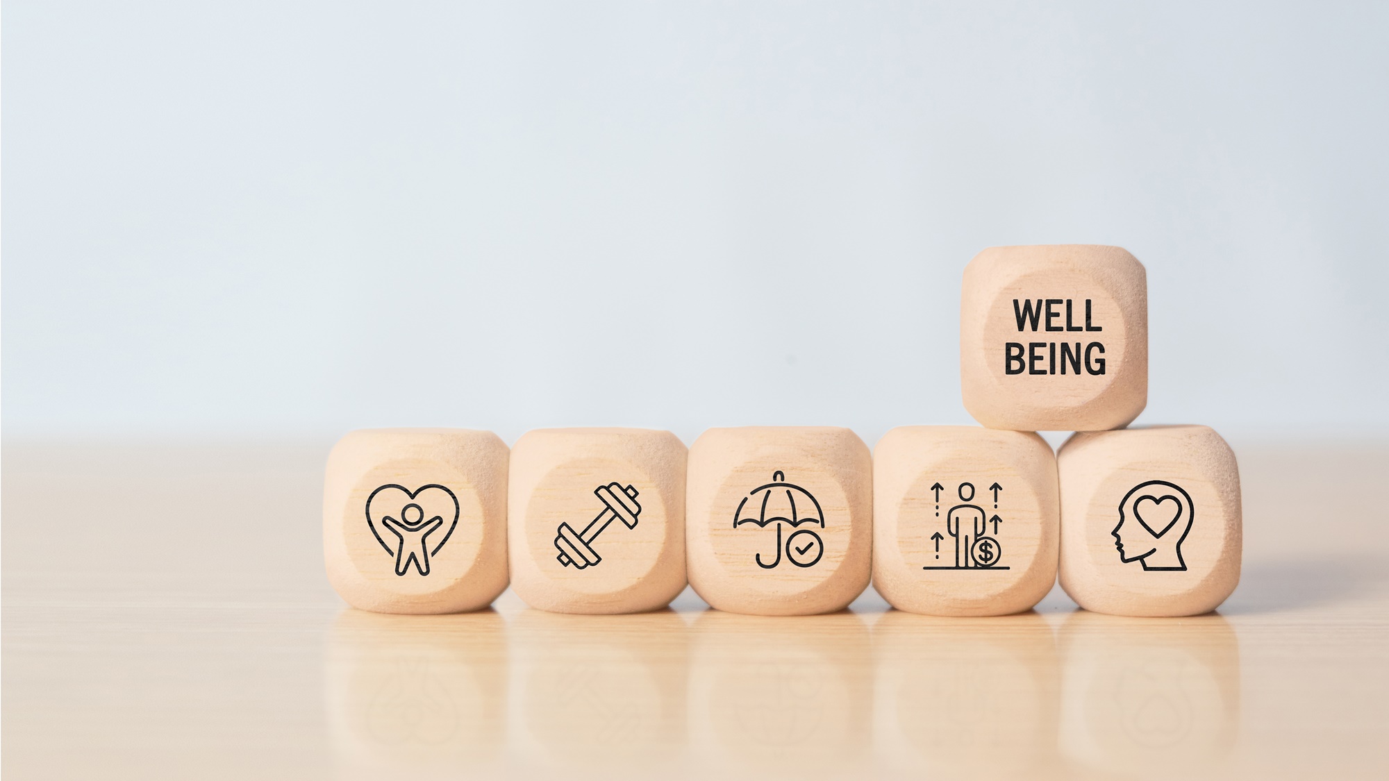 Drewniane symbole przedstawiające elementy wellbeingu pracowników